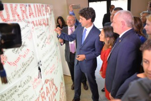 Прем’єр–міністр Канади  Джастін Трюдо залишає підпис "Слава Україні" на стінці виставки.