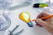 Designer drawing a light bulb, concept for brainstorming and ins
