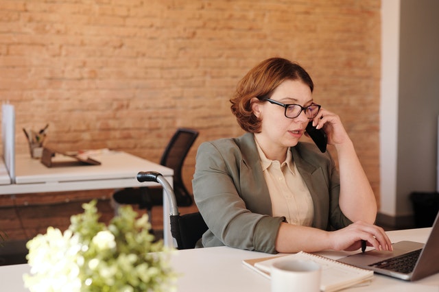 photo-of-woman-talking-through-smartphone-while-using-laptop-4064227