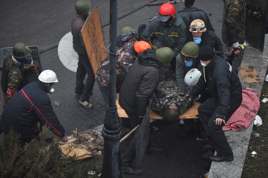 Майданівці виносять смертельно пораненого побратима Андрія Дигдаловича. У червоному шоломі - Іван Куліш, який згодом загине, воюючи у батальйоні "Айдар". Фото: Олексій Фурман.