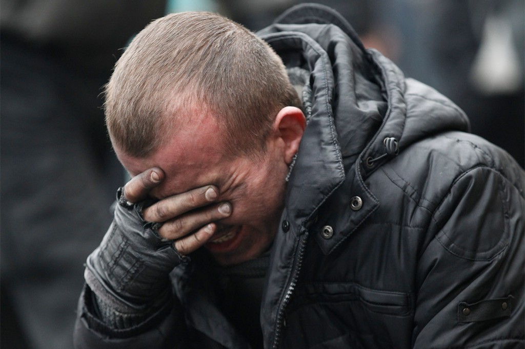 Андрій плаче над тілом дядька Андрія Дигдаловича, вбитого на Майдані. Фото: Василь Федосенко.