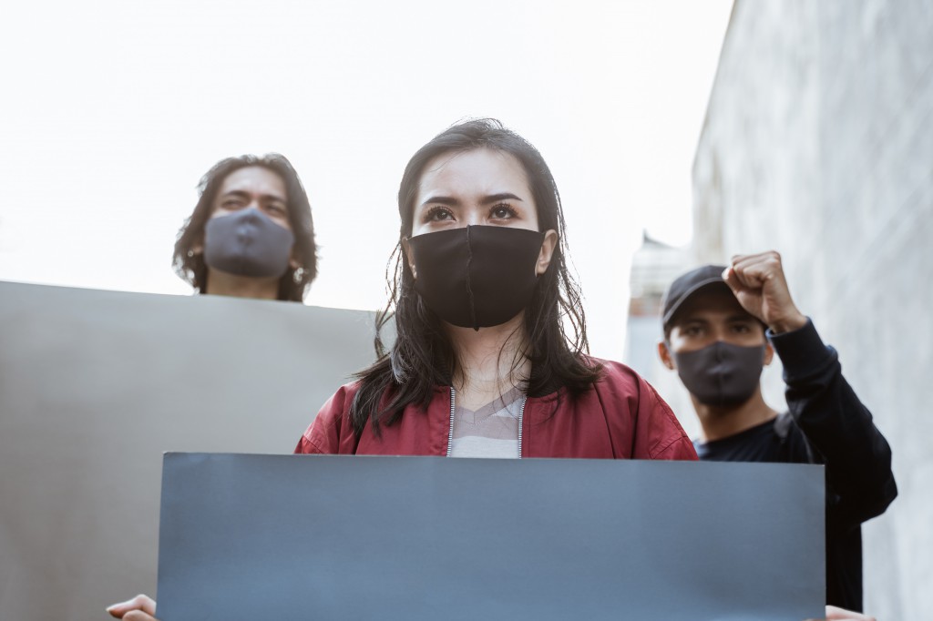 Portrait students holding blank paper conducting demonstrations