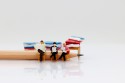 Miniature people reading book with pencil, education or business concept.