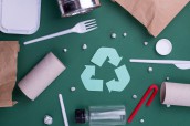 Reuse reduce recycle flat lay concept with plastic, paper, and polyethylene waste. Ecology background image with recycling symbol.