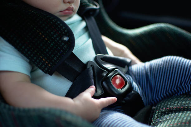 Baby in rear facing car seat  has the safety belt on