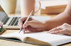 unrecognizable-woman-sitting-desk-indoors-writing-planner