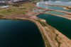 Aerial shot of a landscape surrounded by mountains and lakes with industrial disaster