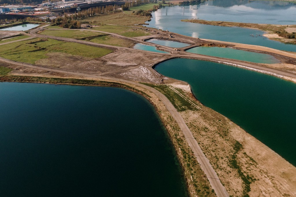 Aerial shot of a landscape surrounded by mountains and lakes with industrial disaster