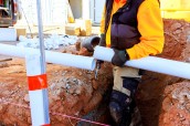 stock-photo-worker-laying-plastic-pipes-trench-construction-site